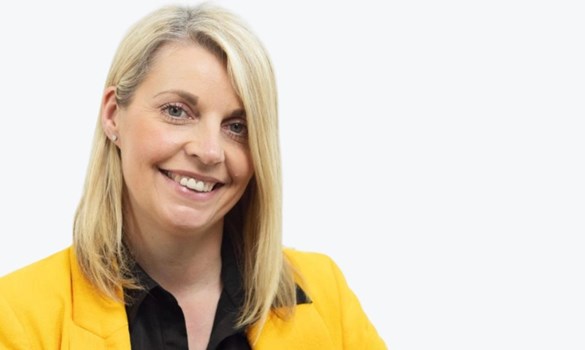 Headshot of woman with blonde bob wearing yellow blazer and black shirt